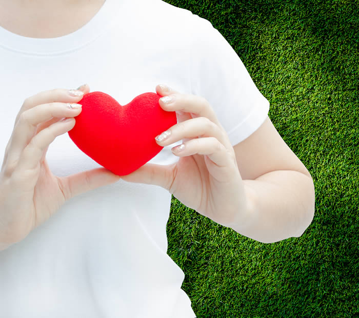 Persona sosteniendo un corazón rojo como símbolo de amor y apoyo emocional en centros de rehabilitación de Grupo Calma